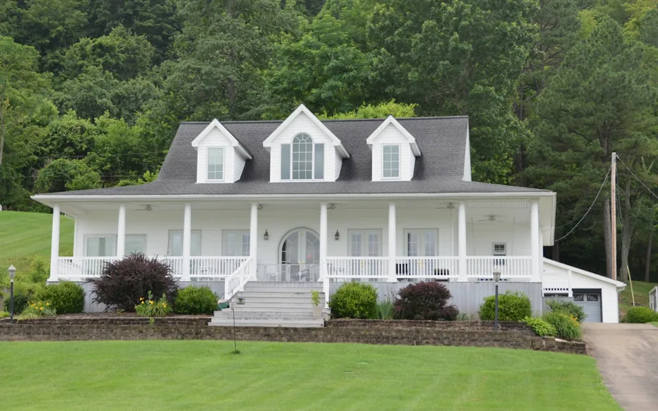 White porch-front home with a neatly maintained lawn — sample design photography